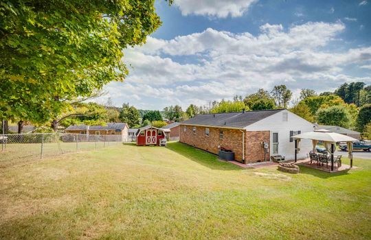 back yard, back of home, fencing, storage building, brick, vinyl siding, one story home