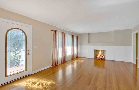 Living room, fireplace, hardwood flooring, entry door