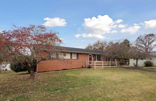 Brick ranch, landscaping, trees, front yard, porch railing, front porch, front door, driveway