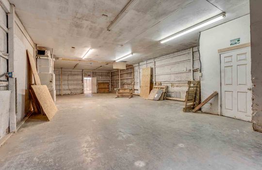 building 2, work area, concrete flooring, garage doors, storage shelves