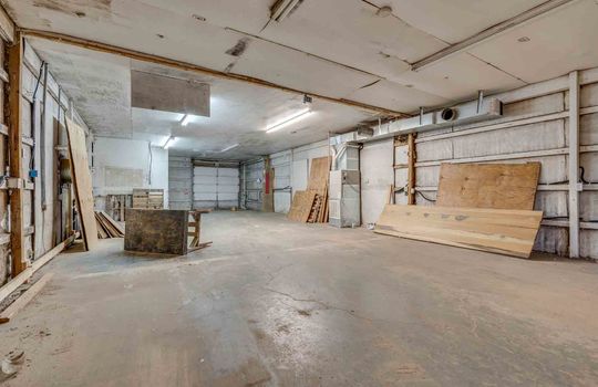 building 2, work area, concrete flooring, garage doors, storage shelves