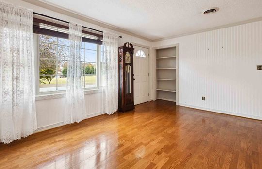 Living room, hardwood flooring, front door, built-in shelving