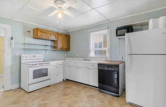 kitchen, vinyl flooring, cabinets, counters, stove, dishwasher, refrigerator, sink, window
