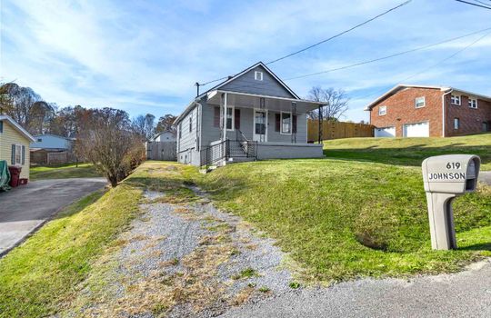 one story, cottage, gravel driveway, front yard, front porch, front door, fencing
