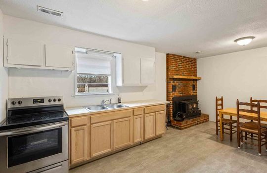 eat in kitchen, dining area, brick fireplace, kitchen, window above sink, sink, cabinets, stainless steel stove