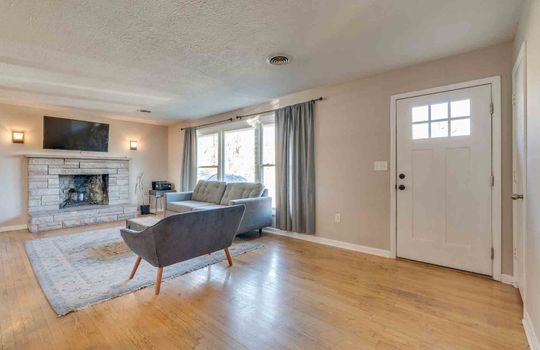 living room, hardwood flooring, large window, fireplace