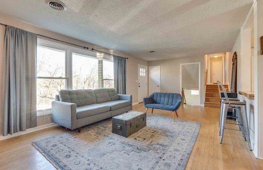 living room, hardwood flooring, stairs to upper level, coat closet