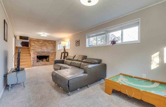 lower level den, brick fireplace, carpet, windows