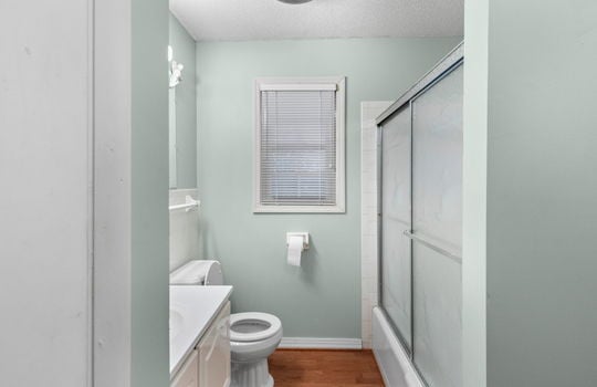 freshly painted bathroom, hardwood flooring/laminate, sink, toilet, shower/tub, sliding shower door
