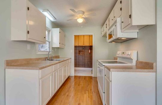 kitchen, cabinets, countertops, electric range, microwave, door to utility room