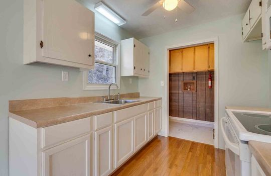 kitchen, cabinets, countertops, electric range, microwave, door to utility room, sink, window above sink