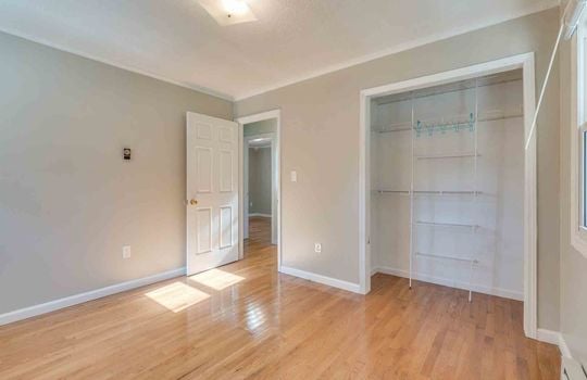 bedroom, hardwood flooring, closet, wire shelving, door to hallway