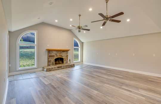living room, arched windows, fireplace, ceiling fans, recessed lighting, luxury vinyl plank flooring