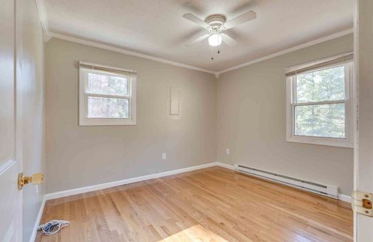 bedroom, baseboard heating, windows, ceiling fan, hardwood flooring