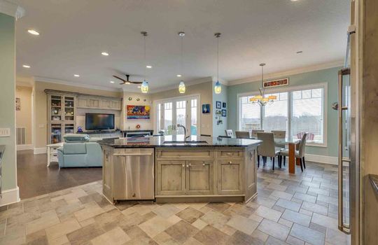 kitchen island, dining area, picture windows, exterior doors to back deck, open to living room, recessed lighting, sink,