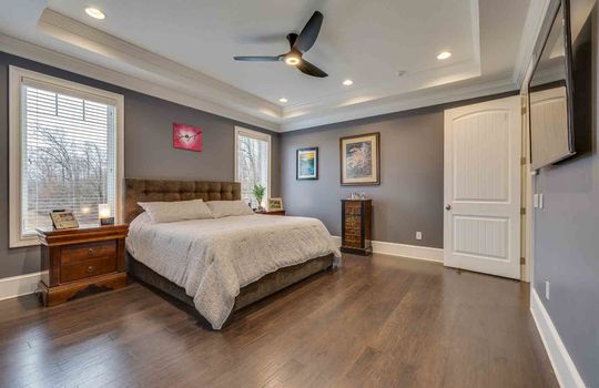 primary bedroom, tray ceilings, ceiling fan, door to hallway