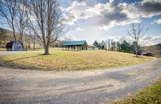 driveway, gravel driveway, side yard, metal roof, ranch style home, covered carport