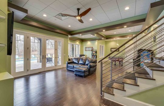 lower level living area, recessed lighting, luxury vinyl flooring, exterior door to back yard/pool area, windows