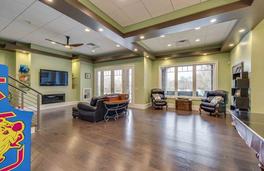 lower level living area, recessed lighting, luxury vinyl flooring, exterior door to back yard/pool area