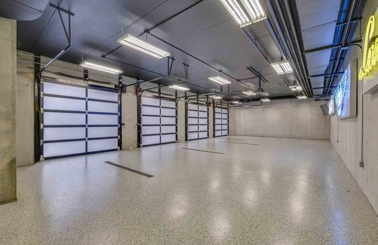 garage, concrete/epoxy flooring, garage, garage doors, fluorescent lighting, shelving