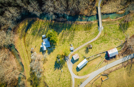 aerial view of property, home, barns, secondary homes, creek, bridge,