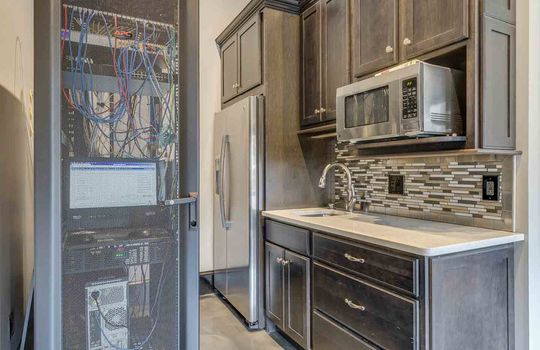 stand alone garage mini kitchen, cabinets, tile backsplash, built in stainless microwave, stainless refrigerator