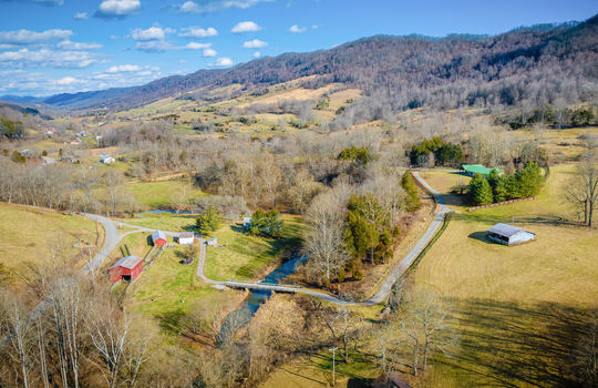 aerial view of property, creek, bridge, barns, driveway, main home