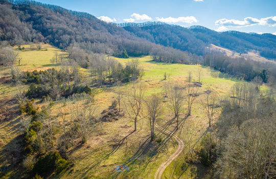 aerial view of property, pasture, trees, forest, mountains