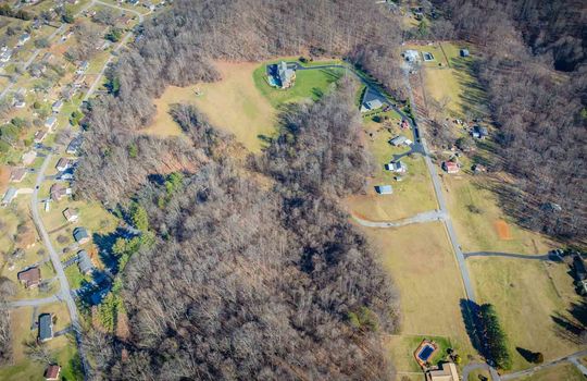 aerial view of property, brick home, paved driveway, 25.72+/- acres, trees