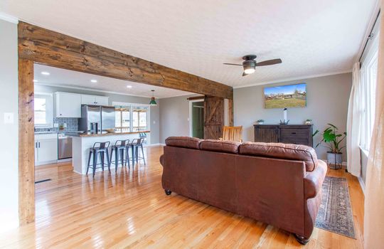 living room, hardwood flooring, wood beam, window, ceiling fan