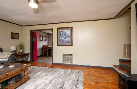 living room, paneling walls, hardwood flooring, ceiling fan