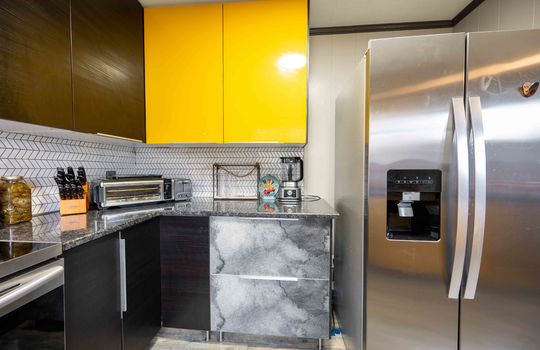 kitchen, modern cabinetry, stainless steel refrigerator, stainless steel stove, countertops, luxury vinyl flooring