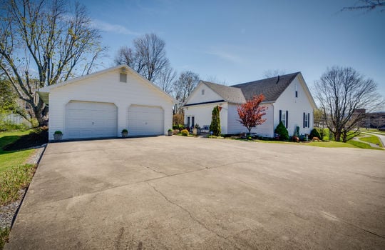 concrete driveway, detached garage, two level historic home, landscaping