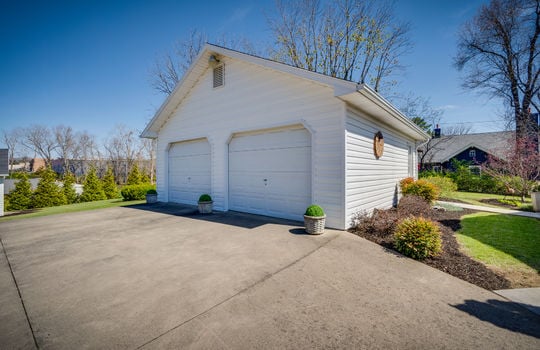 detached garage, two garage doors, concrete driveway, landscaping