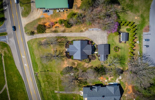 aerial view of property, roof, driveway, road, detached garage, storage house