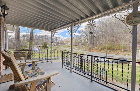 covered front porch, concrete, railing, view of front yard