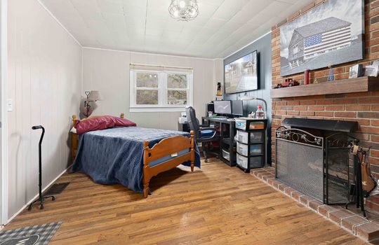 bedroom, hardwood flooring, fireplace, brick fireplace