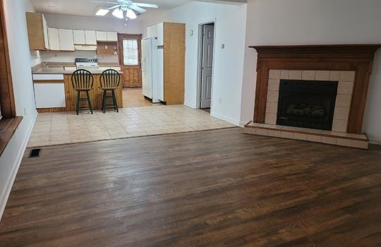 living room, fireplace, kitchen, eat-in kitchen, refrigerator, cabinets, vinyl flooring