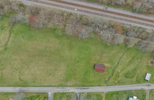aerial view over acreage with outbuilding, road, mountain views, total acreage 14.75+/- acres