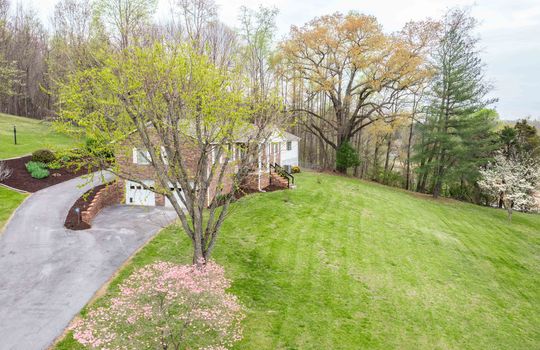 front yard, brick ranch, mature landscaping, driveway, two car drive under garage, trees