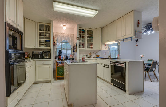 kitchen, cabinets, island with cooktop, tile flooring, dishwasher,