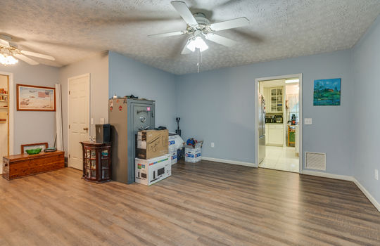 primary suite, vinyl flooring, ceiling fan, windows, exterior door, closet, door to hallway