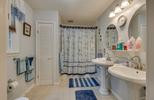 primary bathroom, pedestal sinks, linen closet, shower/tub
