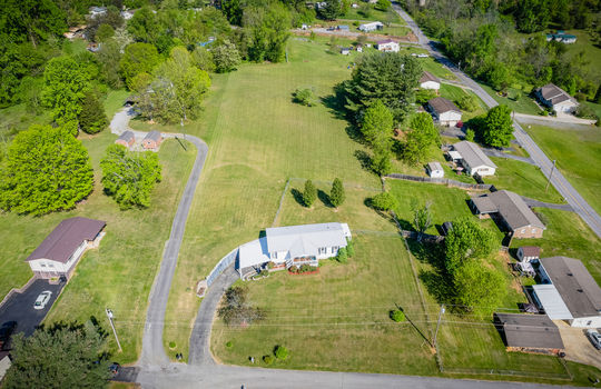aerial view of property, road, driveway, double wide, back yard, fence, trees, landscaping