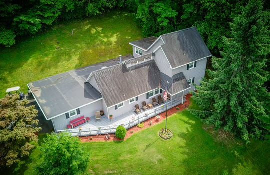 aerial view over front of home, landscaping, front porch, vinyl siding, shingle roof