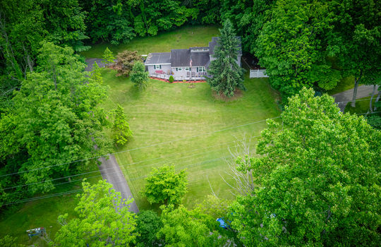 aerial view toward front of home, front yard, landscaping, trees