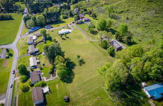 aerial view from back of property toward road, trees, double wide