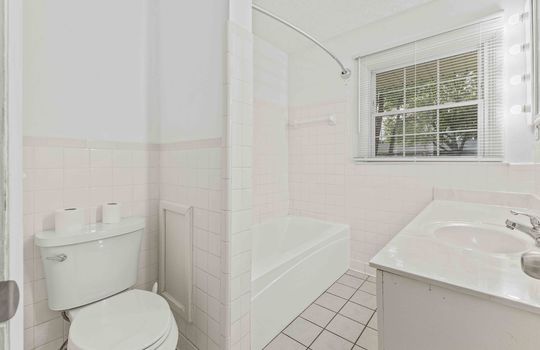bathroom, tile flooring, toilet, shower/tub, sink, cabinet