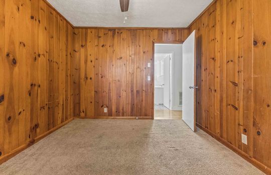 bedroom, knotty pine walls, ceiling fan, carpet