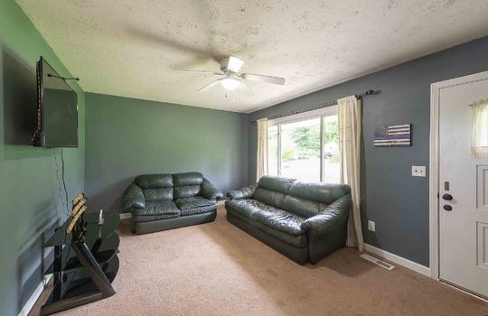 living room, front door, carpet, ceiling fan